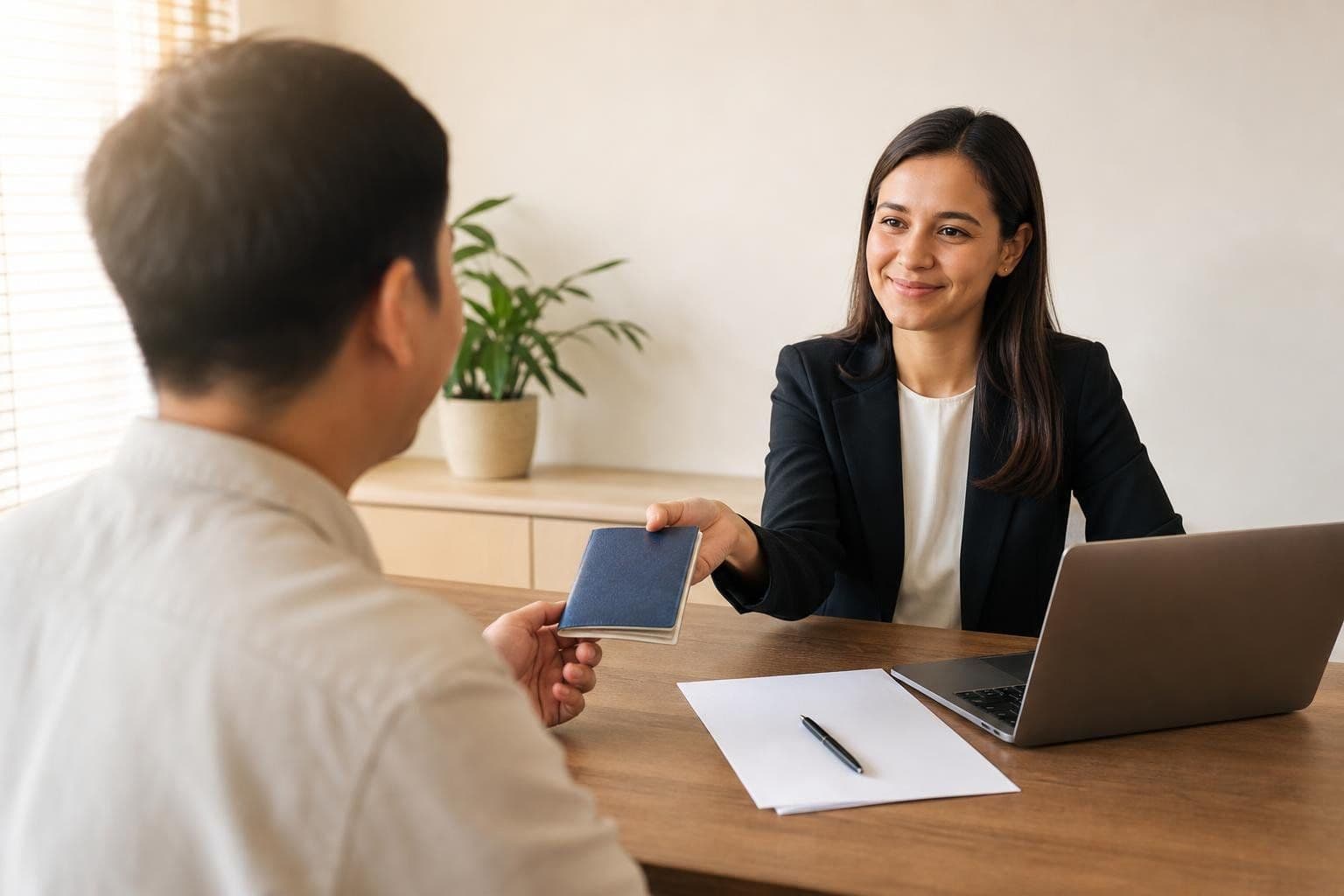 A tax professional at a desk handing a passport back to a client across the table